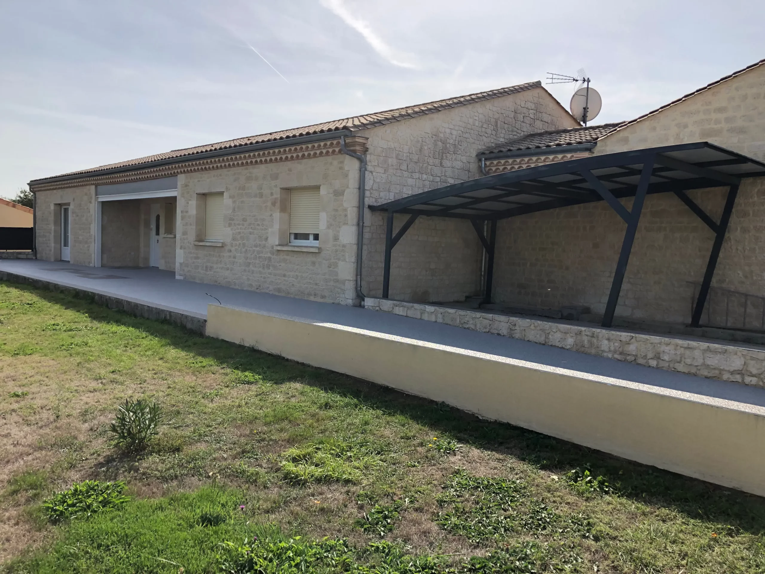 Vue de côté du carport installé par Naturéo, spécialiste de l'aménagement extérieur de vos maison dans le grand Bergeracois.