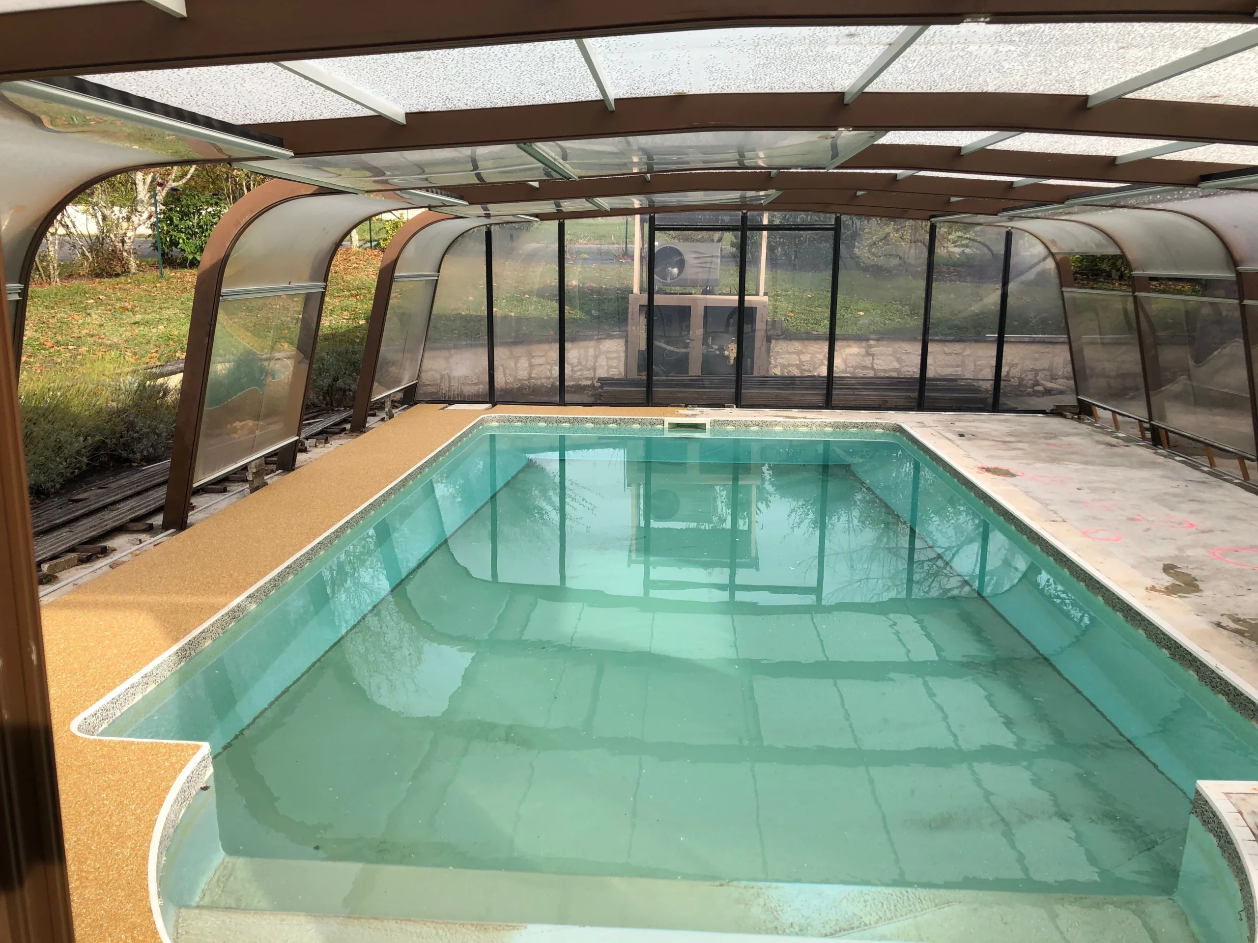 Vue sur l'avancement des travaux pour une terrasse couverte avec piscine.